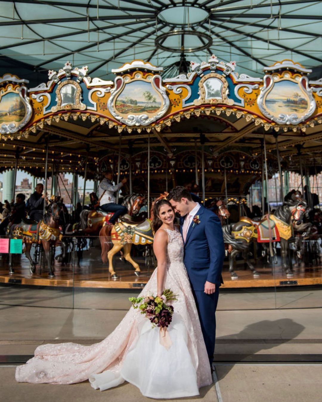 Bride and groom in front of merry go 'round